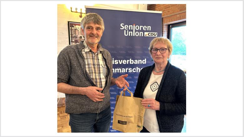 Imker Hans-Jürgen Löbkens bekommt von der Seniorenunionvorsitzenden Anne Ohlsen als Dank ein Tasche voll mit nordischen Produkten.