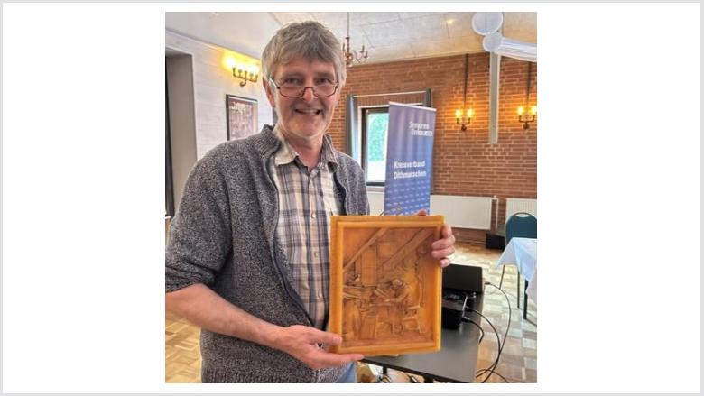 Imker Hans-Jürgen Löbkens aus Lunden mit einem Relief aus Bienenwachs.
